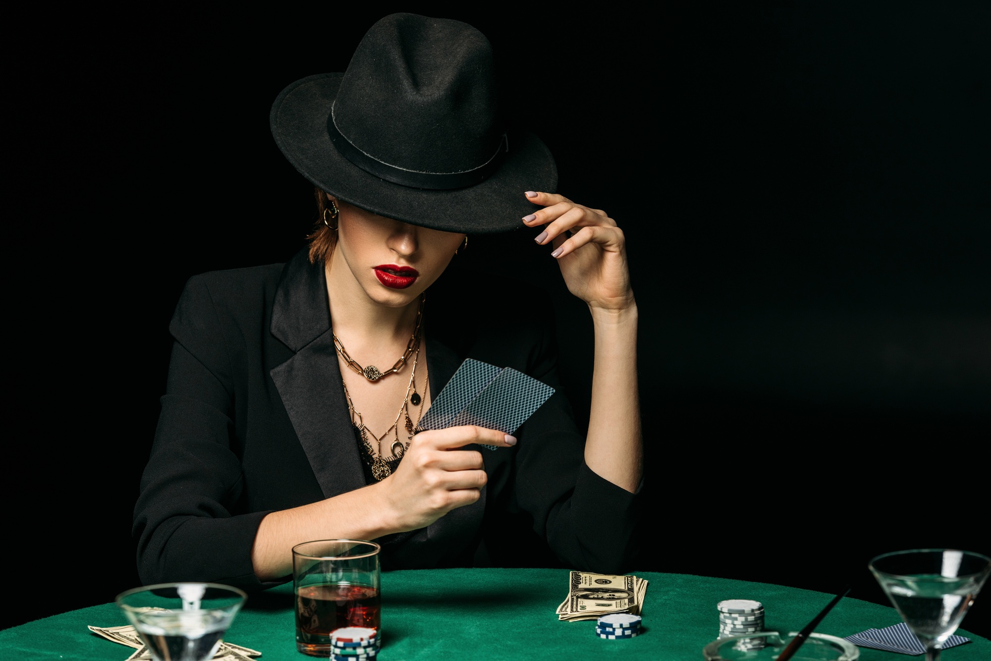 attractive girl in jacket and hat playing poker in casino