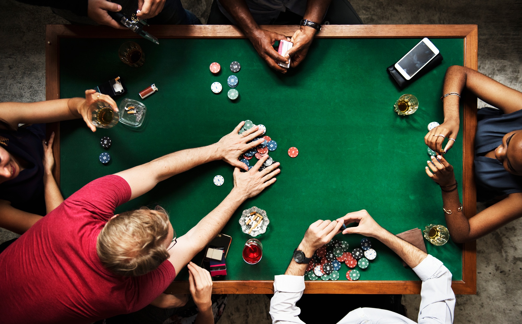 Diverse group playing poker and socialising